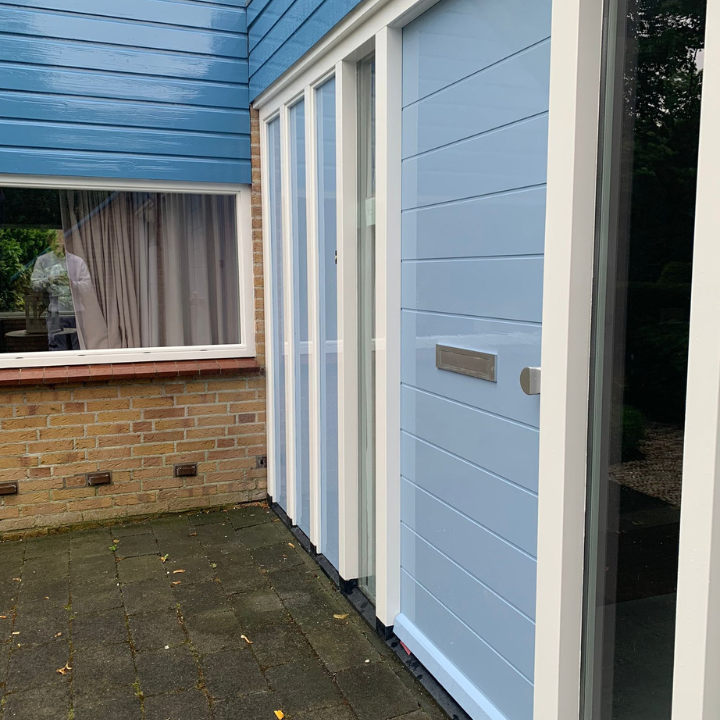Voorkant van de woning netjes geschilderd met blauw, licht blauw en wit